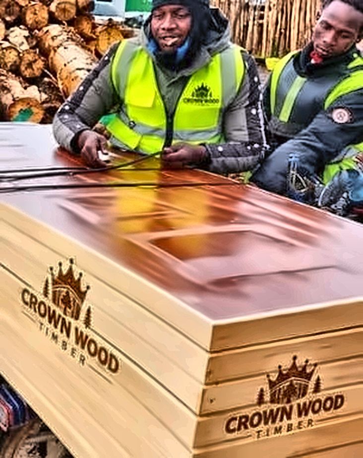 Two workers strapping a stack of doors for delivery