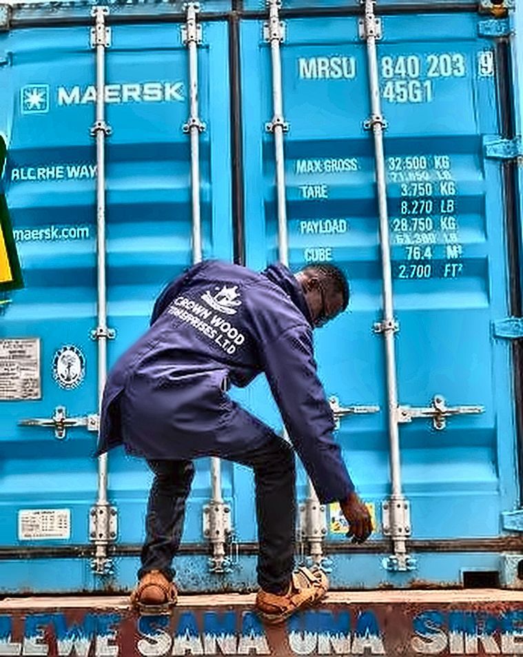 A Crown Wood worker climbing a shipping container on a lorry